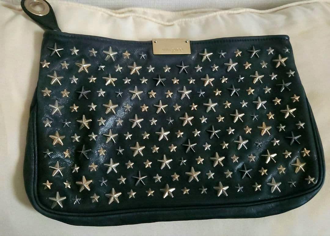 Front view of a JIMMY CHOO cow leather clutch bag covered in metallic star studs.