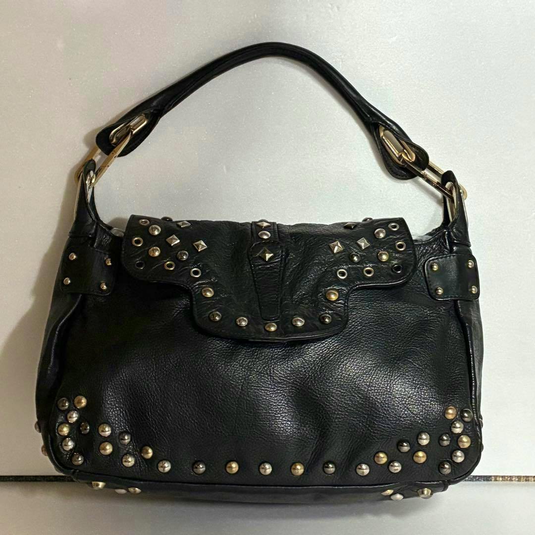 Black studded shoulder bag with a single top handle and metal hardware shown on a plain background.