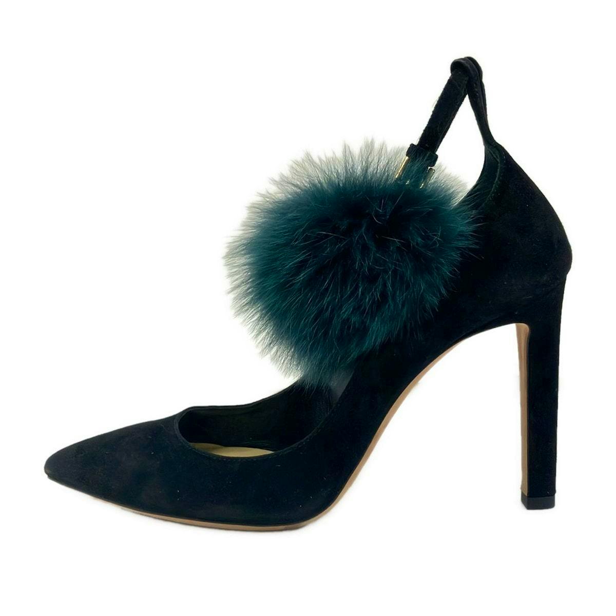 Side view of a JIMMY CHOO black suede women's high-heeled pump with a green fur pompom strap.
