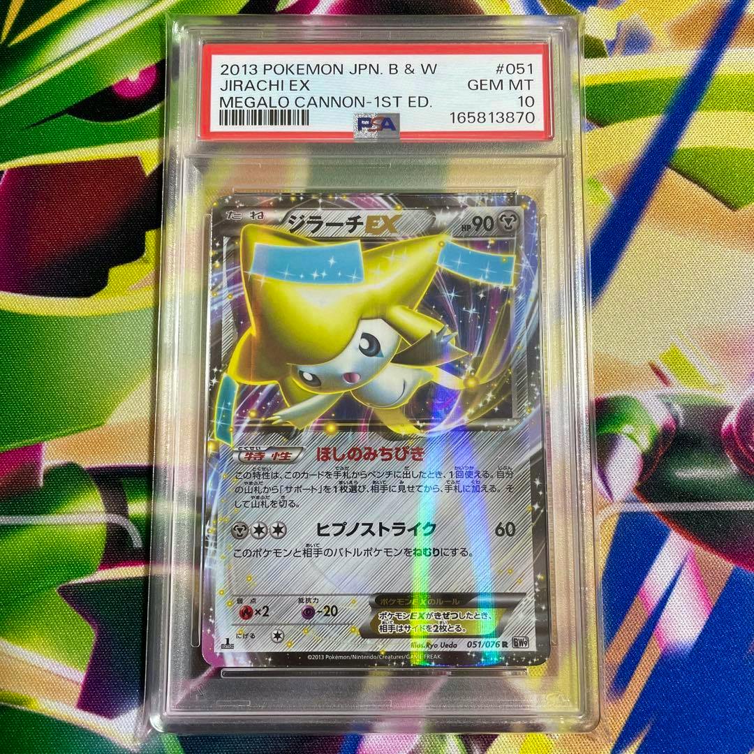 A PSA-graded Japanese Jirachi EX trading card (in a clear plastic slab) with the PSA label and grade visible.