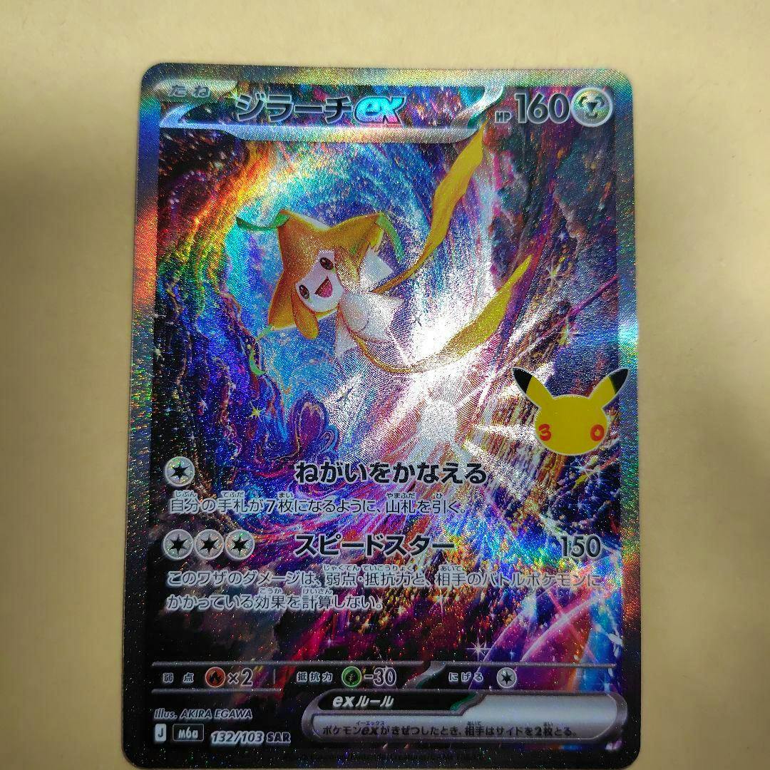 Photograph of the holo trading card ジラーチex SAR 132/103 30th showing the full card on a beige background.