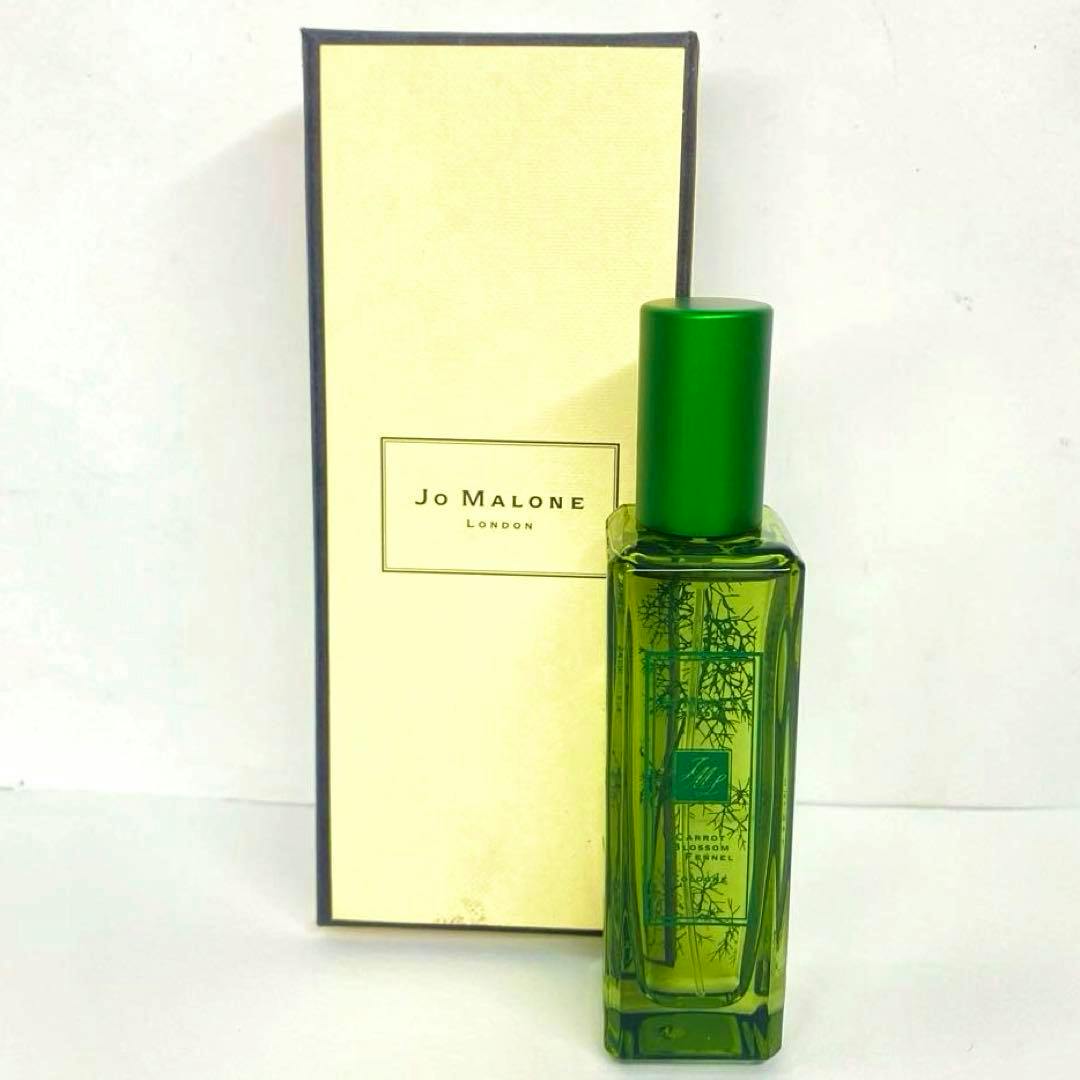 A green Jo Malone perfume bottle (Carrot Blossom & Fennel) standing in front of its Jo Malone London box.