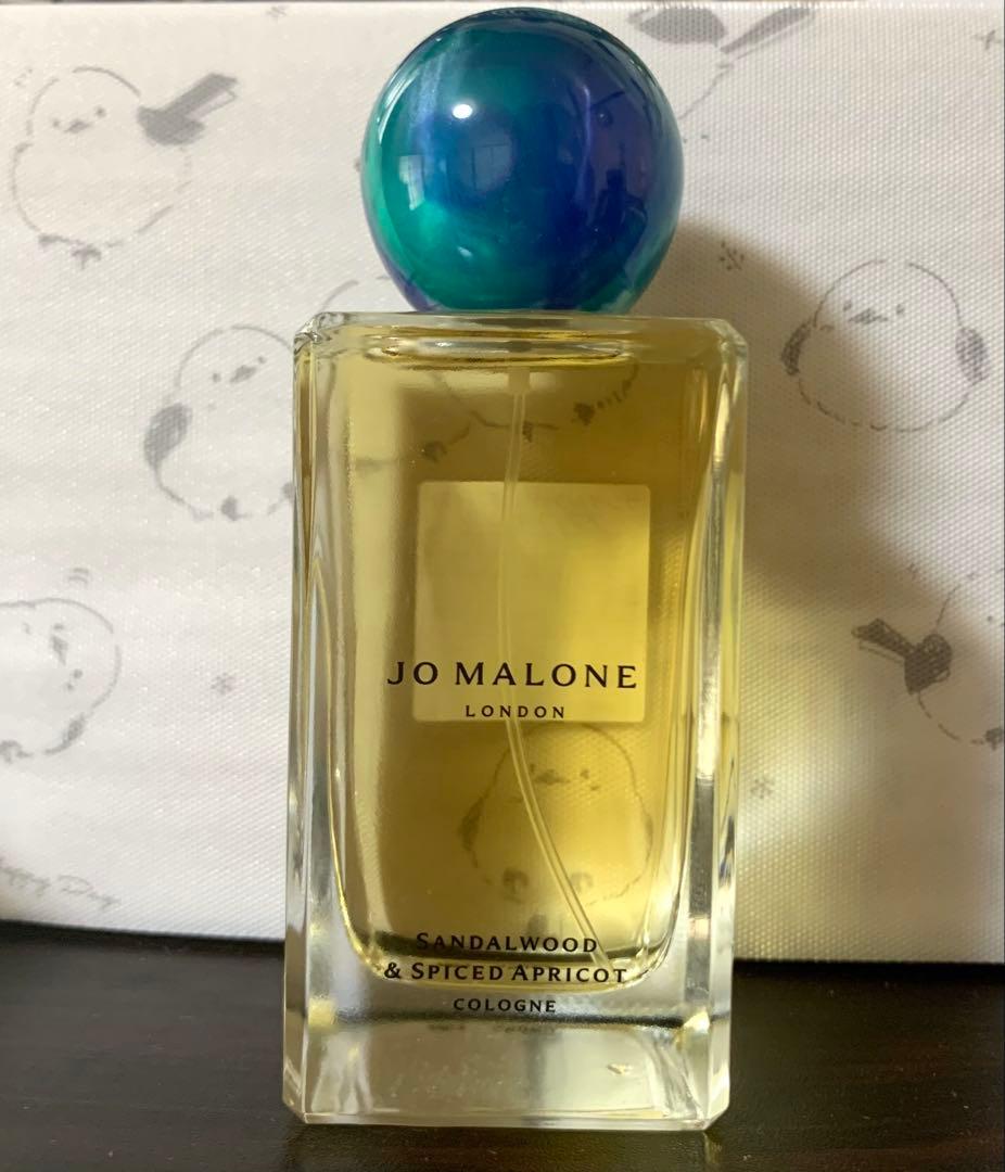 Front view of the Jo Malone Sandalwood & Spiced Apricot 100ml cologne bottle showing the label and a blue-green round cap.