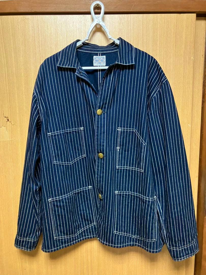 Front view of the ジョーマッコイ 1920s Wabash coverall jacket in navy with white vertical stripes, showing four patch pockets and brass buttons.