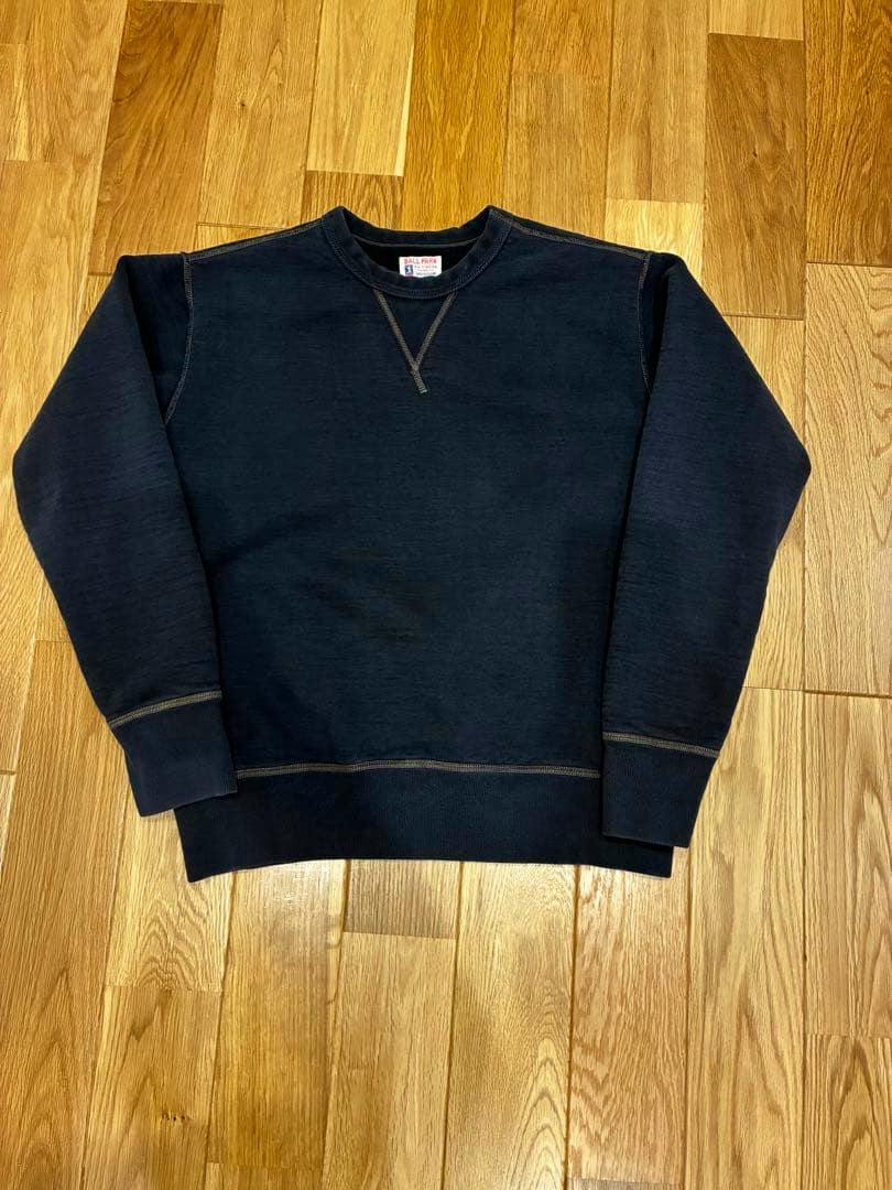 Dark navy JOE McCOY BALL PARK cotton sweatshirt laid flat showing the front on a wooden floor.