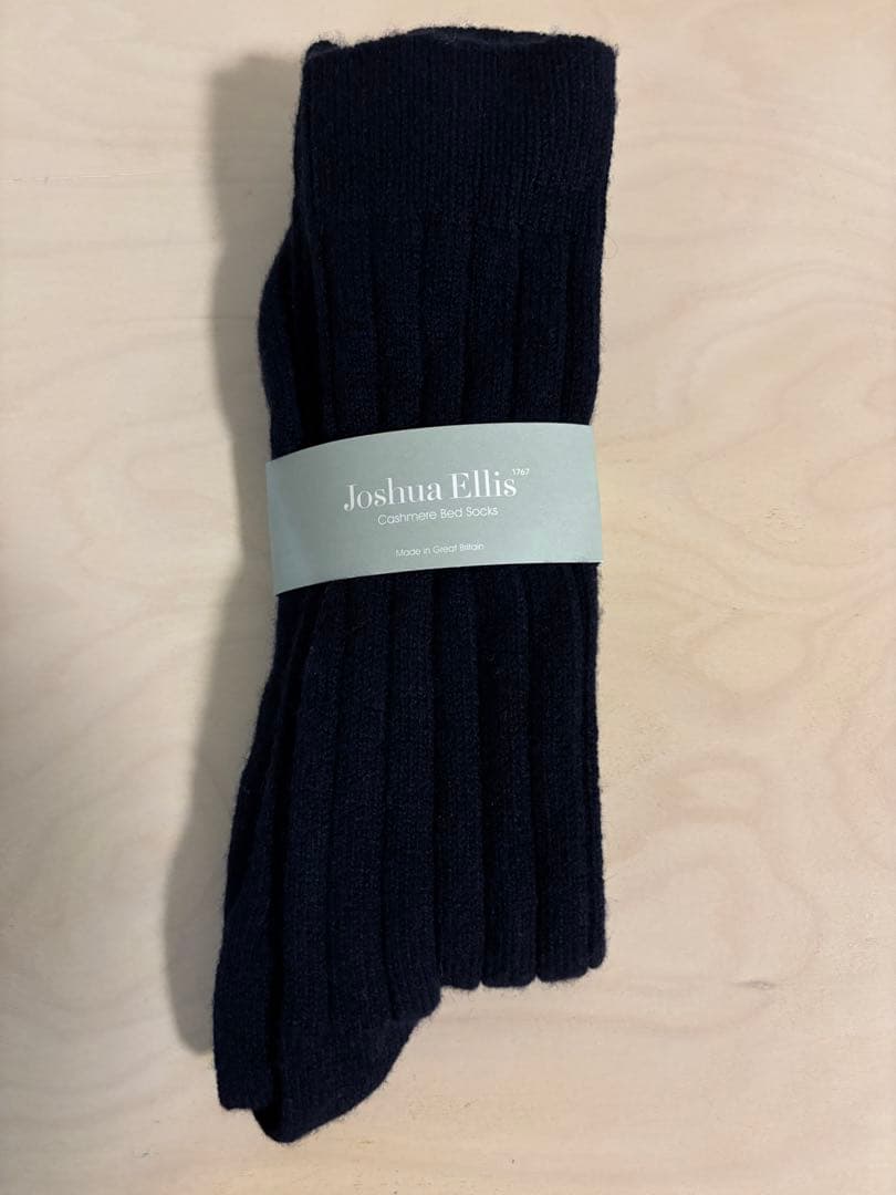 Dark ribbed Joshua Ellis cashmere bed socks laid flat with the product band label visible.