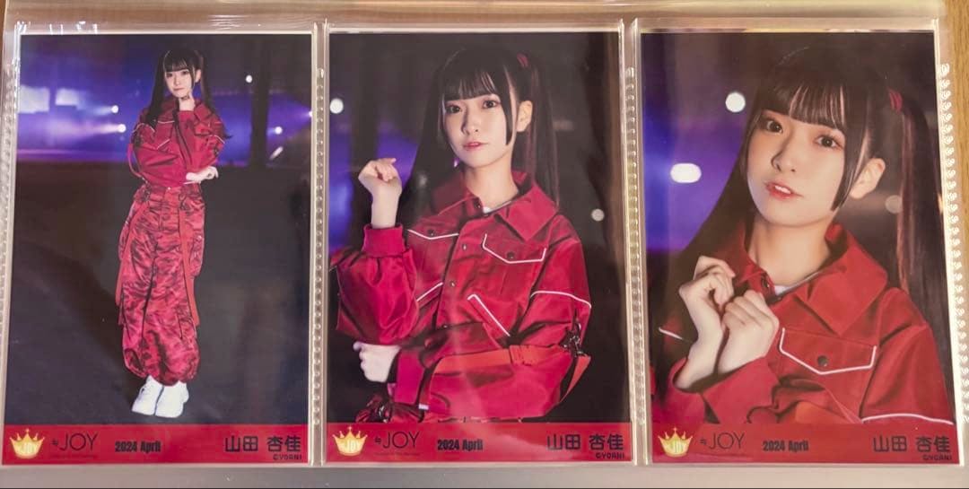Three glossy photocard portraits of a young woman wearing a red outfit, shown side-by-side in clear sleeves.