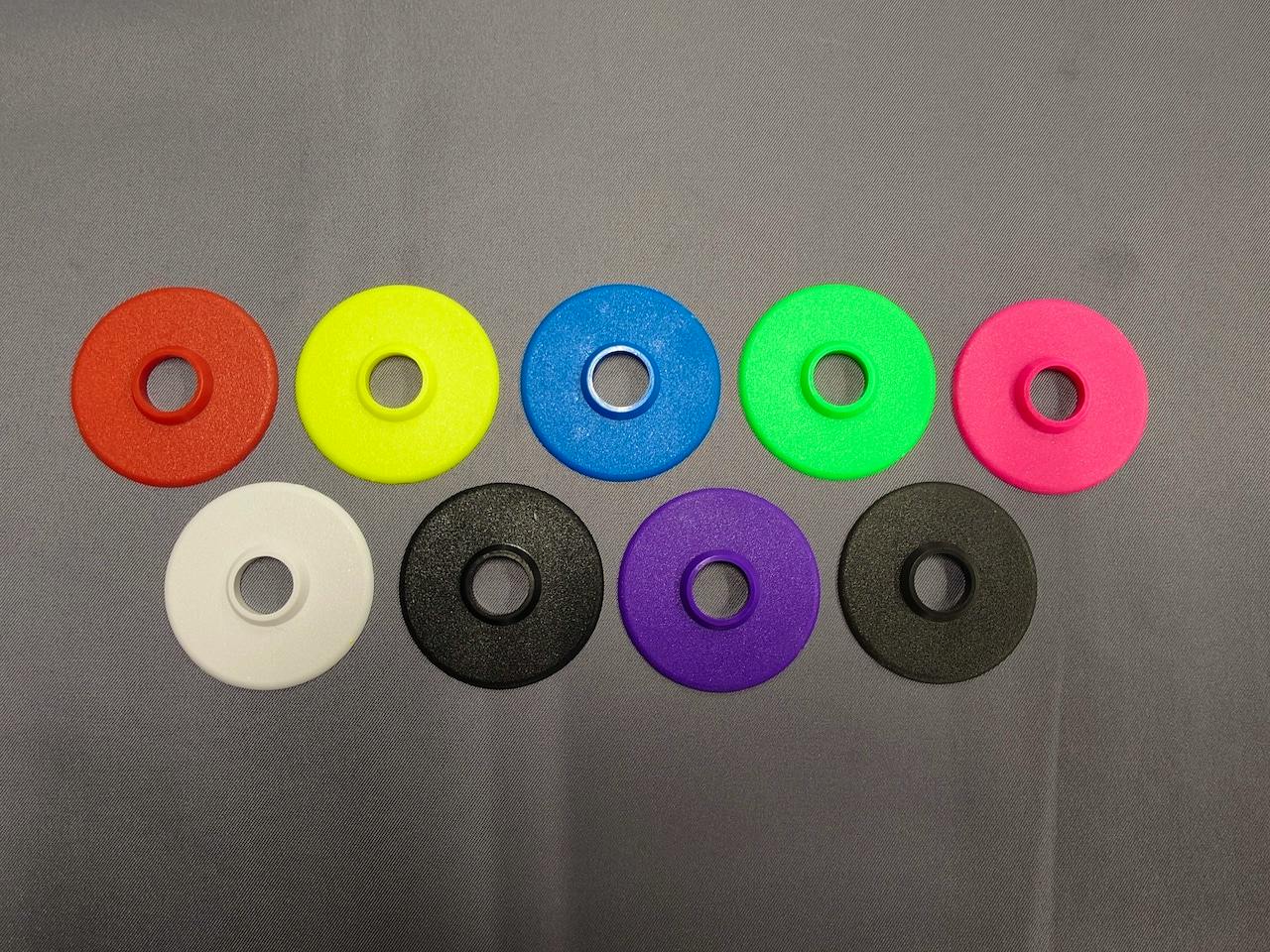 Ten colored circular lever packing washers with central holes arranged on a gray background.