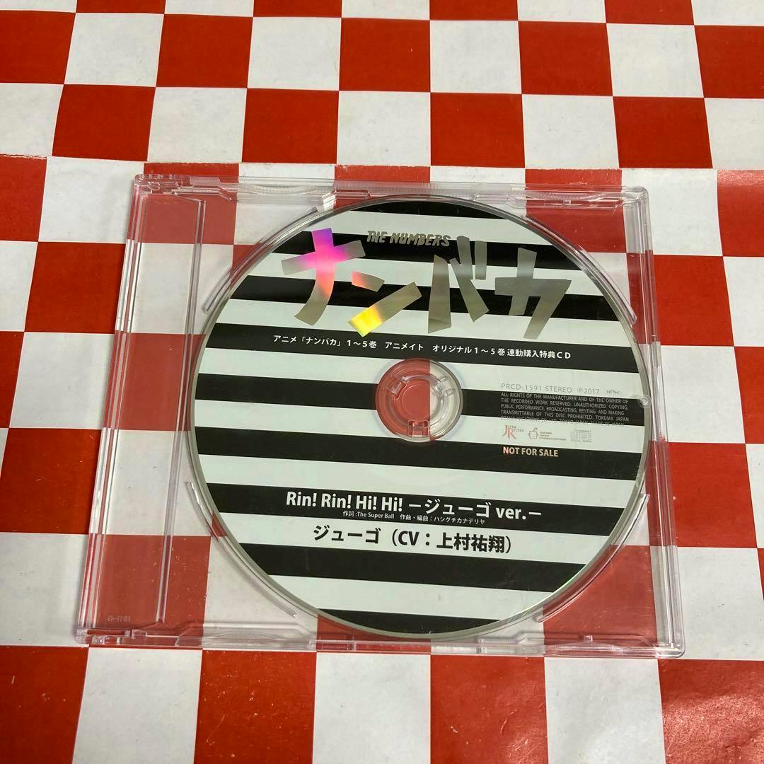 A CD with a black-and-white striped printed label and Japanese text in a clear jewel case on a red-and-white checkered surface.