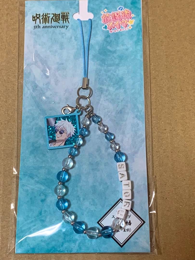 Blue beaded keychain strap for Jujutsu Kaisen showing a square acrylic charm of Satoru Gojo and letter beads spelling "SATORU", on a blue backing card in plastic packaging.