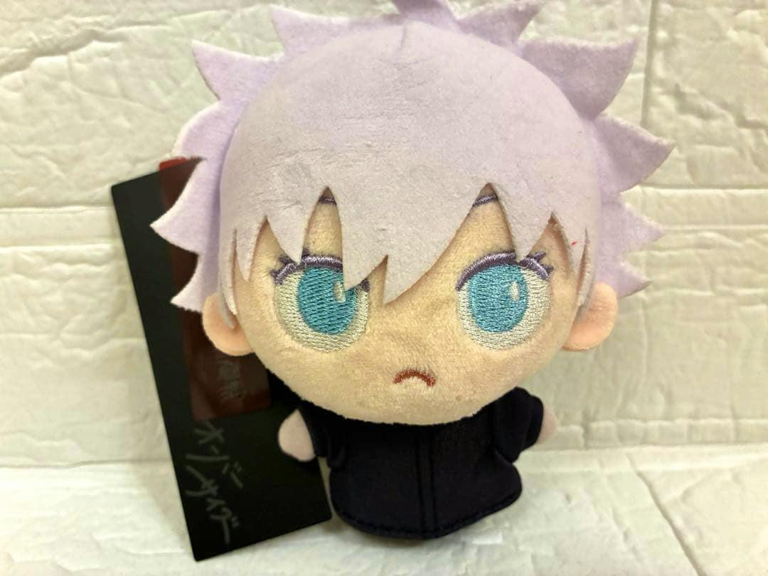 Front view of a Gojo Satoru plush from Jujutsu Kaisen showing light-colored hair, embroidered blue eyes, and a black outfit.