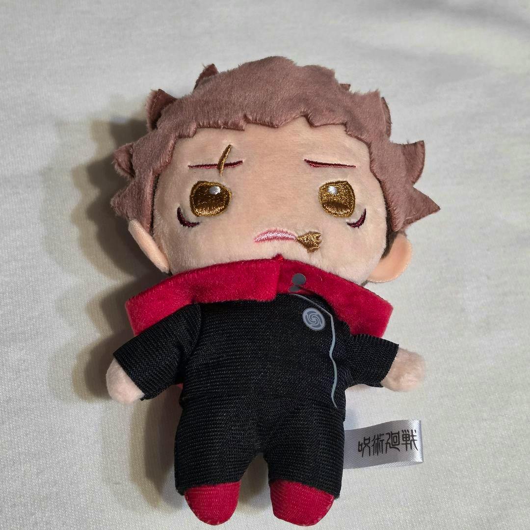 Front view of the Jujutsu Kaisen mascot plush of Itadori Yuji (Sukuna vessel version) lying on a white surface.