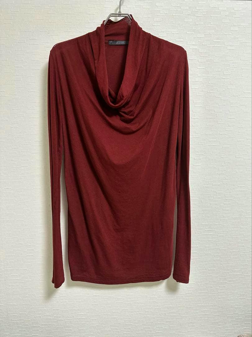 Front view of a long-sleeve maroon cotton-silk jersey T-shirt with a draped cowl neck hanging on a hanger.