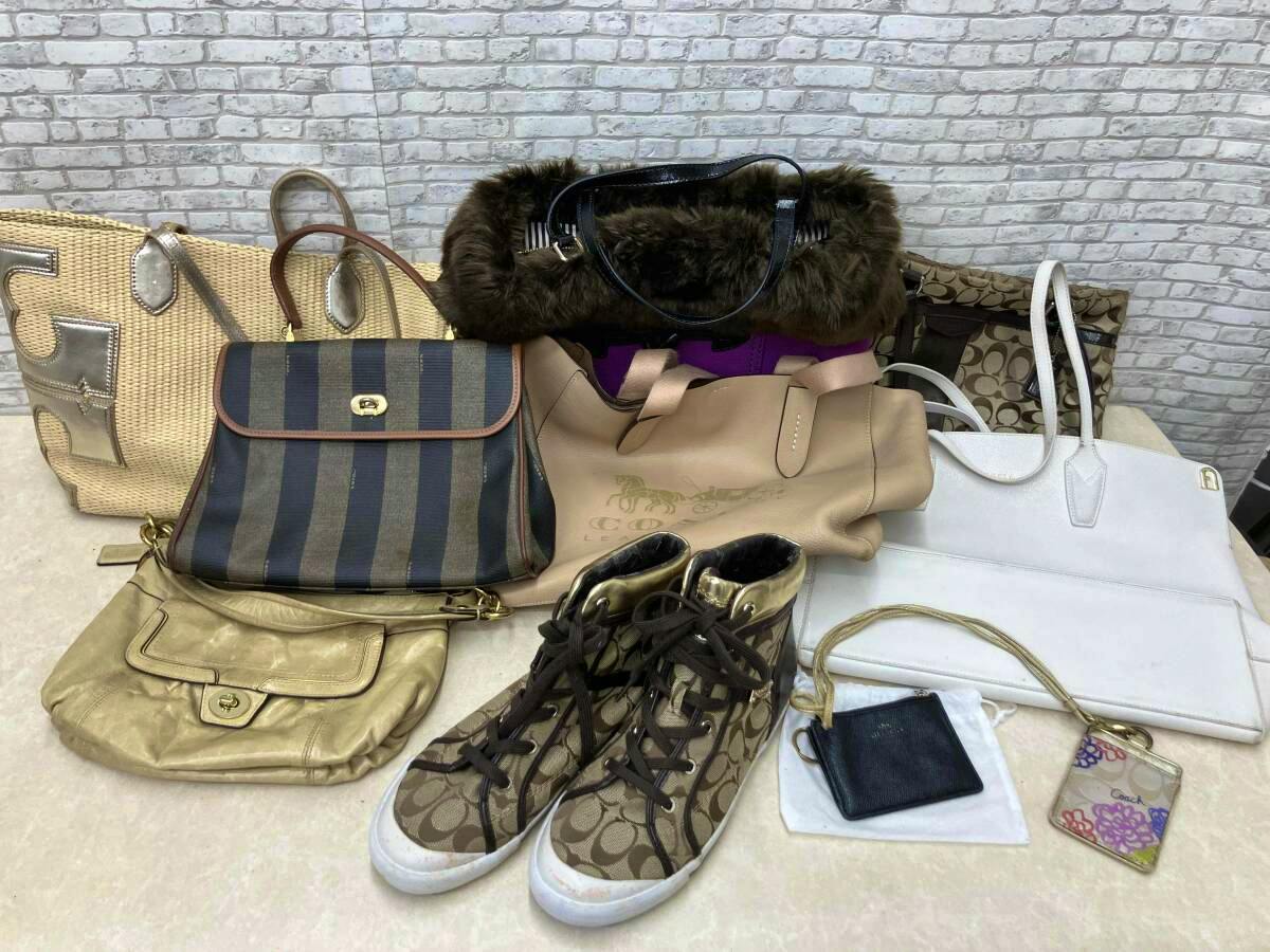 Multiple designer bags, a pair of patterned sneakers, and small accessories displayed together on a surface.