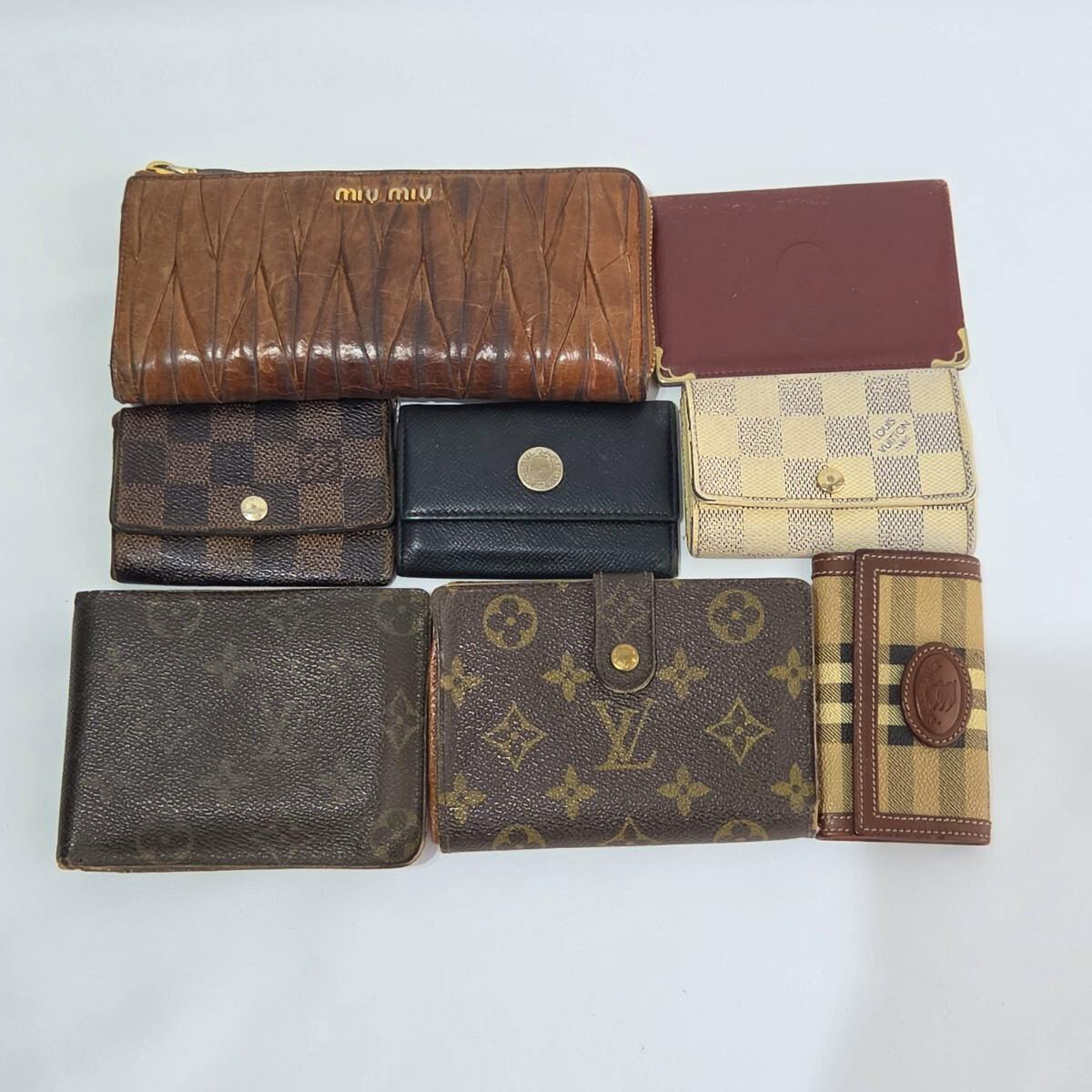 Eight assorted branded wallets and key cases (bundle) laid out on a white background.