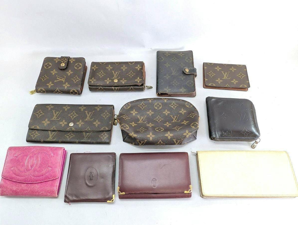 Multiple designer wallets and small leather goods, including Louis Vuitton monogram pieces, arranged on a white background.