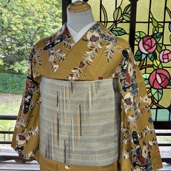 Women's cotton houmongi kimono with a yellow-gold floral pattern displayed on a mannequin with a pale obi.