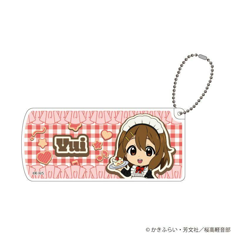 Sliding small plastic case front showing a chibi illustration of Hirasawa Yui in a maid outfit on a pink checkered background with a ball chain attached.