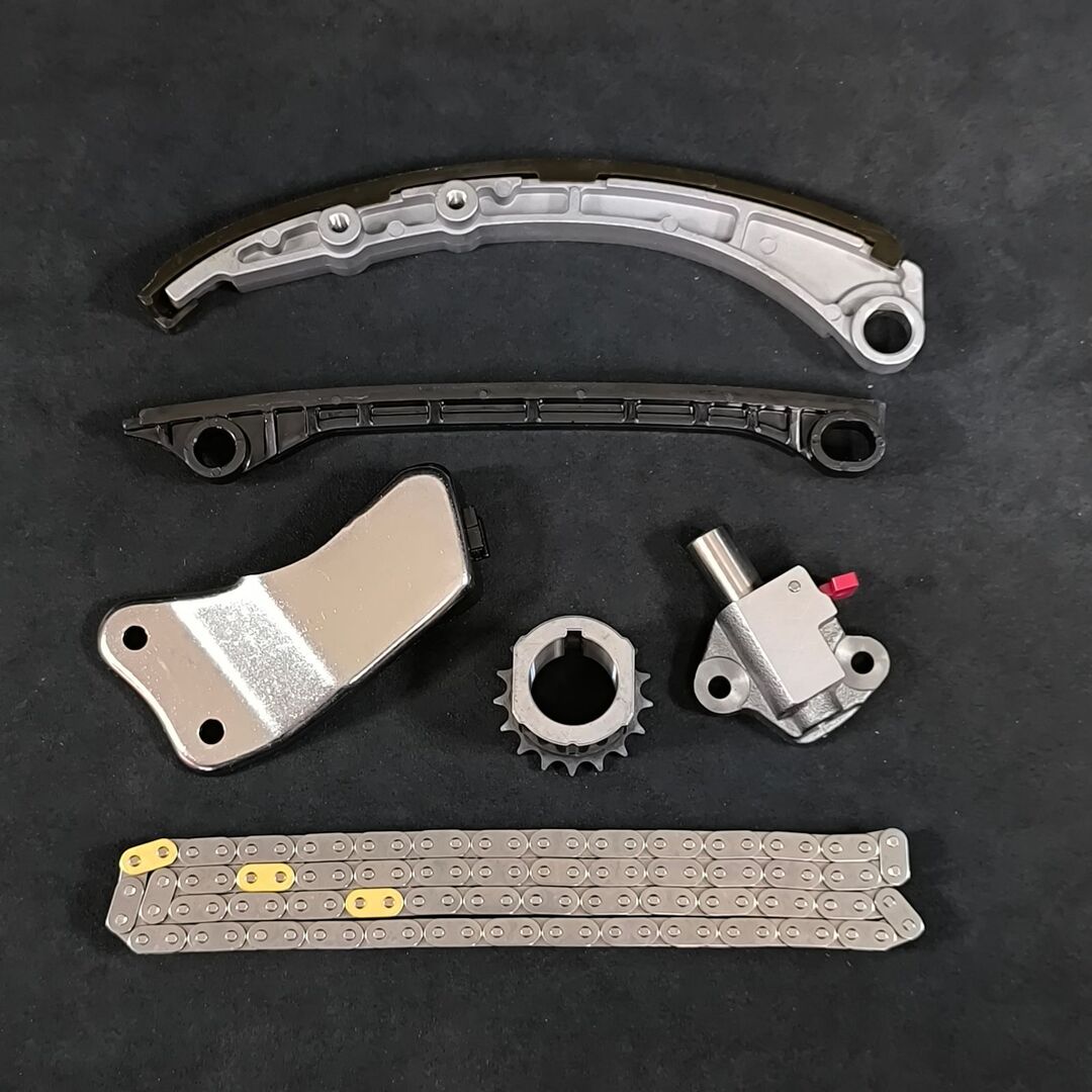K6A timing chain set components (chain, guides, tensioner, sprocket, and bracket) laid out on a black background.