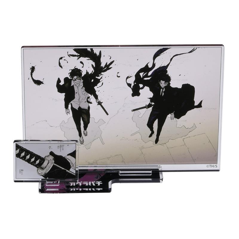 Photo of the acrylic diorama stand showing a black-and-white illustration of two sword-wielding characters and a small rectangular panel mounted on its base.