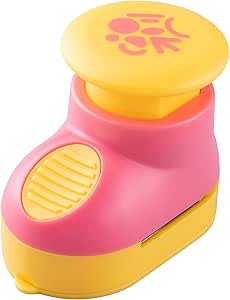A pink and yellow handheld nori punch (seaweed cutter) with a decorative symbol on the round top.