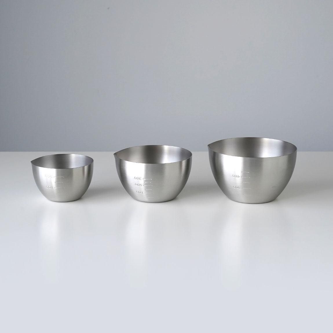 Three stainless steel prep bowls in small, medium, and large sizes arranged on a white surface.