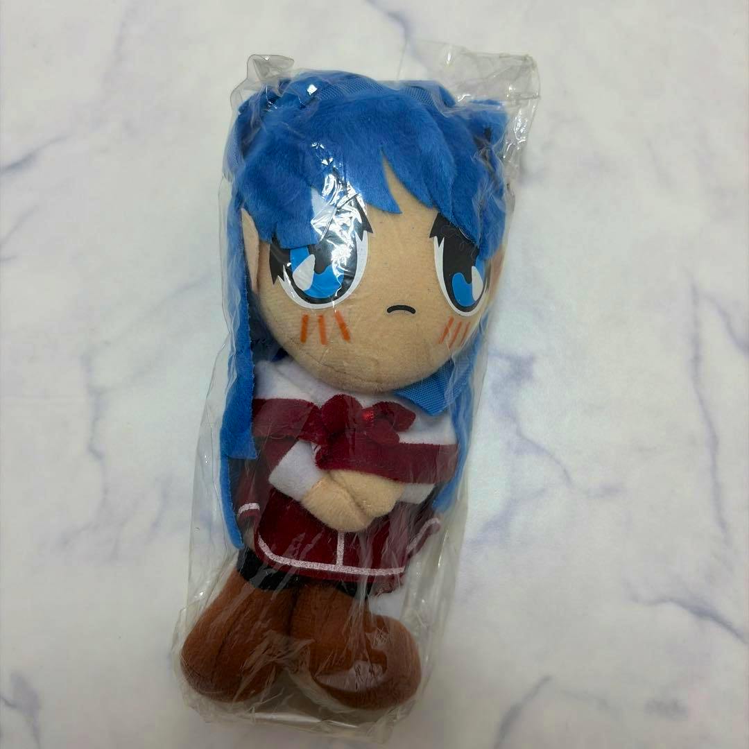 A sealed plush (ぬいぐるみ) of kanon 水瀬名雪 in its unopened plastic bag showing the front with blue hair and red outfit.