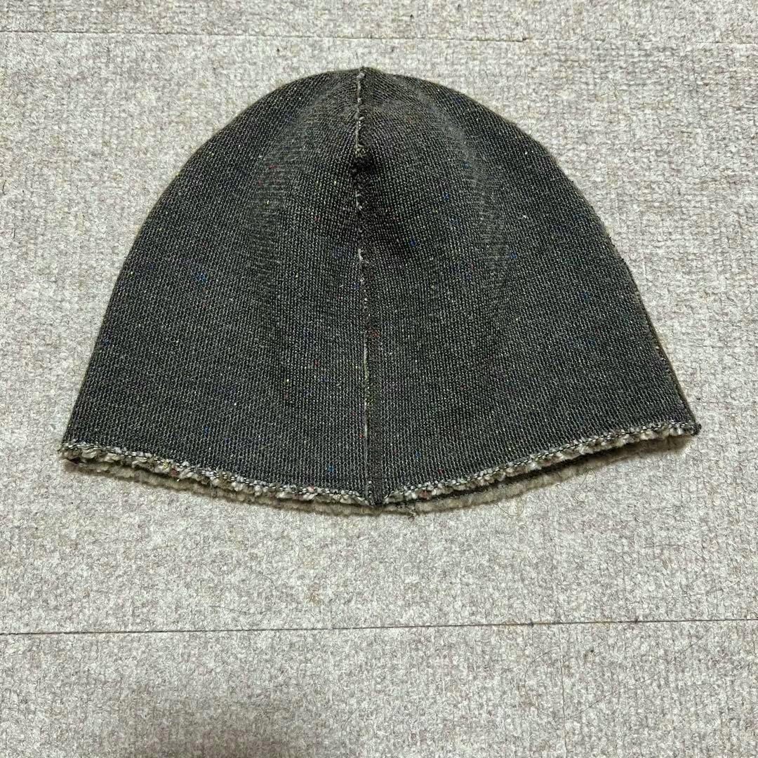 Flat lay of the KAPITAL wool beanie showing the dark exterior and center seam.