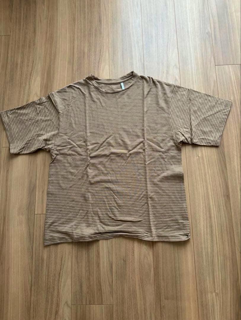 Brown and white striped short-sleeve KAPTAIN SUNSHINE tee laid flat on a wood floor.