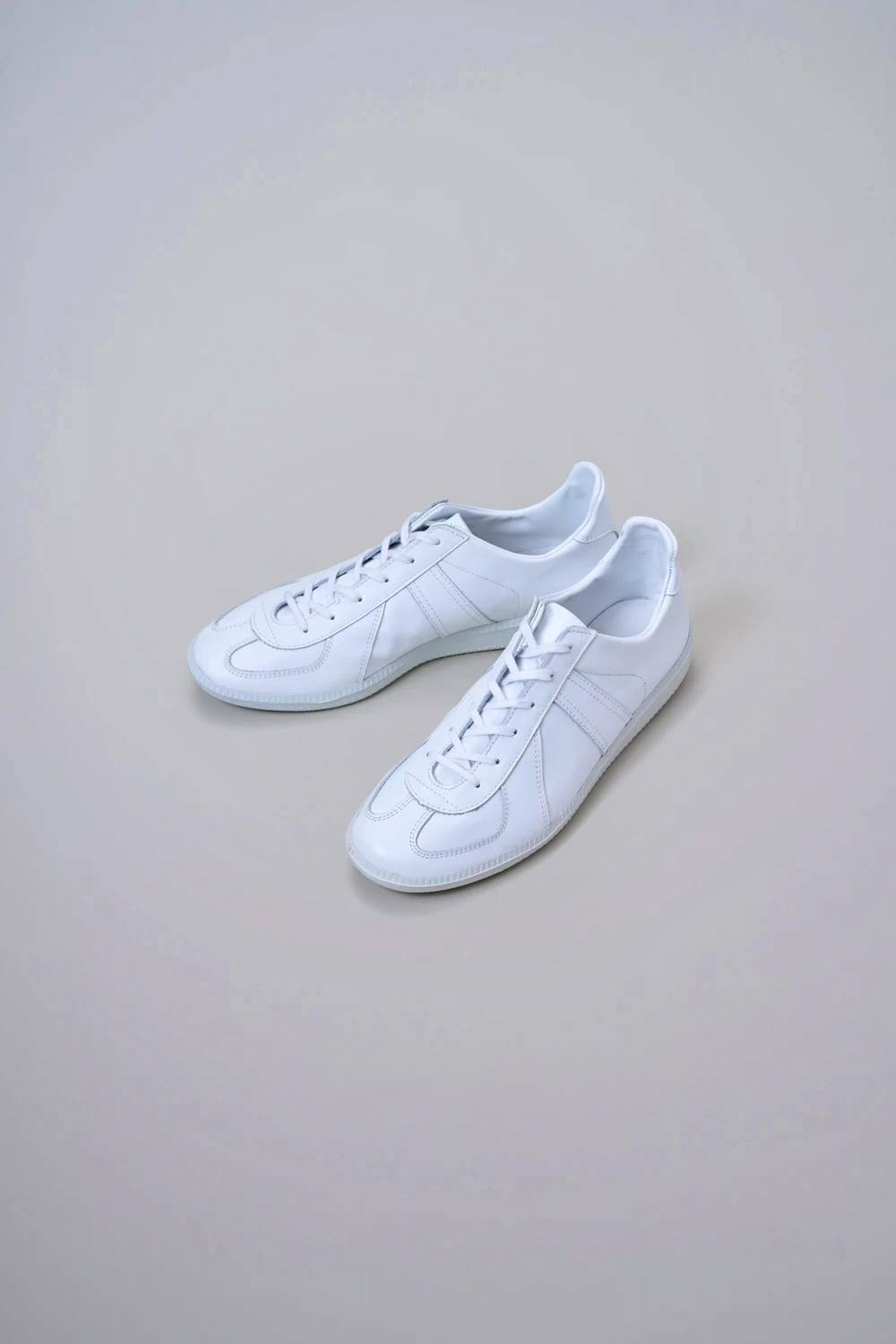 A pair of white Kaptain Sunshine leather trainers photographed on a plain background.