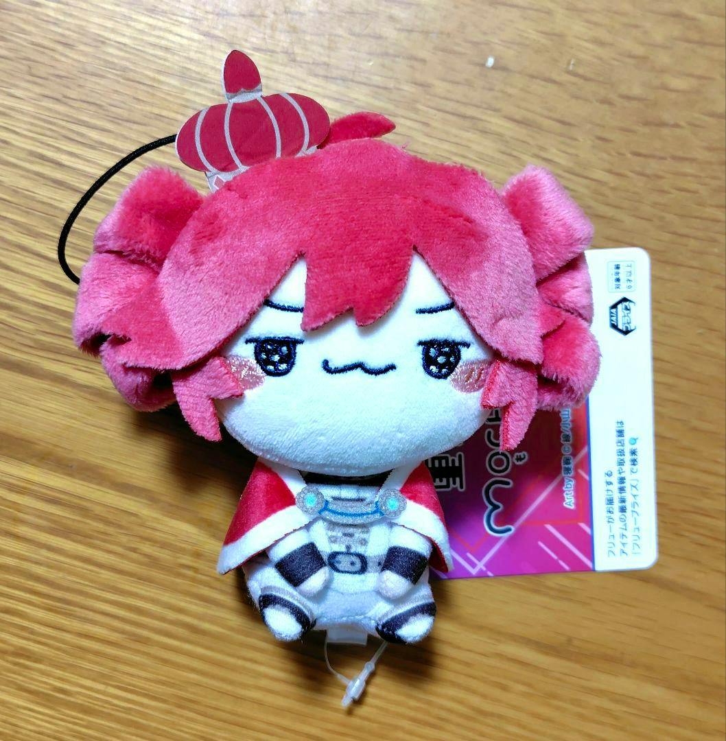 Front view of the 重音テト もちぴこマスコット 『王様ver.』 plush keychain showing the plush's face, crown tag, red cape, and product tag on a wooden surface.
