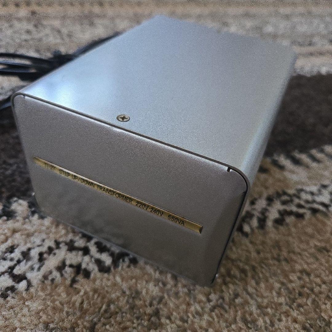 Silver Kashimura TI-27 step up/down transformer on a carpeted surface with its power cord visible.