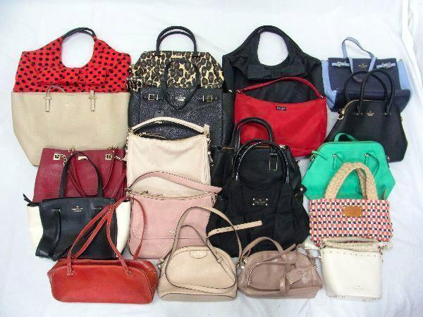 Multiple kate spade handbags and totes arranged on a white surface, showing various colors and styles.