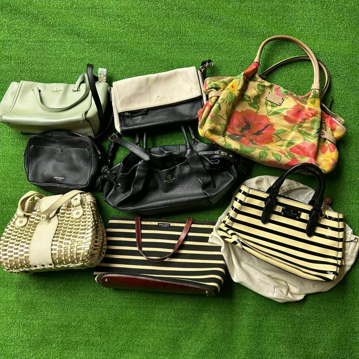 Eight Kate Spade women's bags of various styles arranged on a green surface.