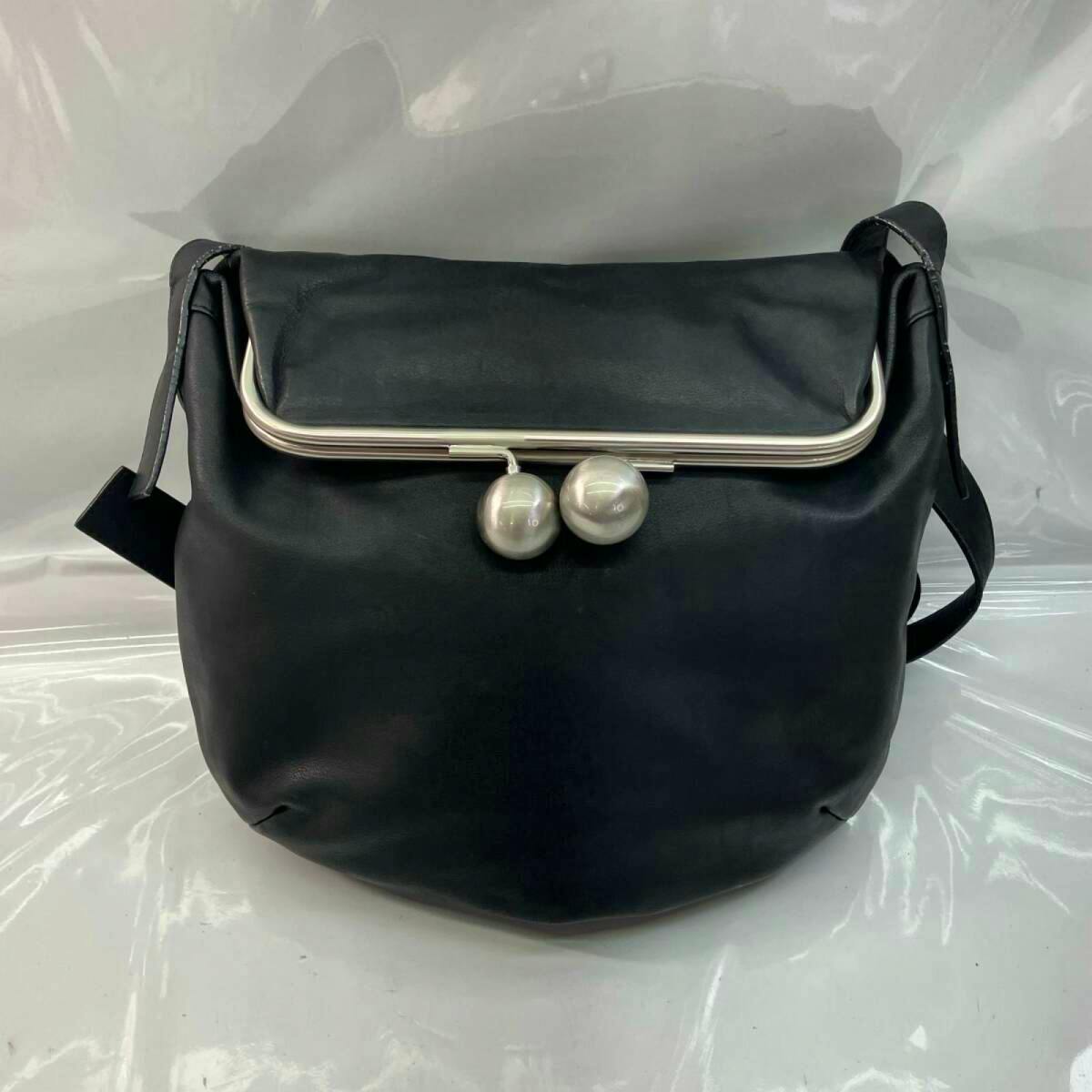 Front view of a black canvas shoulder bag with a silver kiss‑lock frame and two round clasp balls.