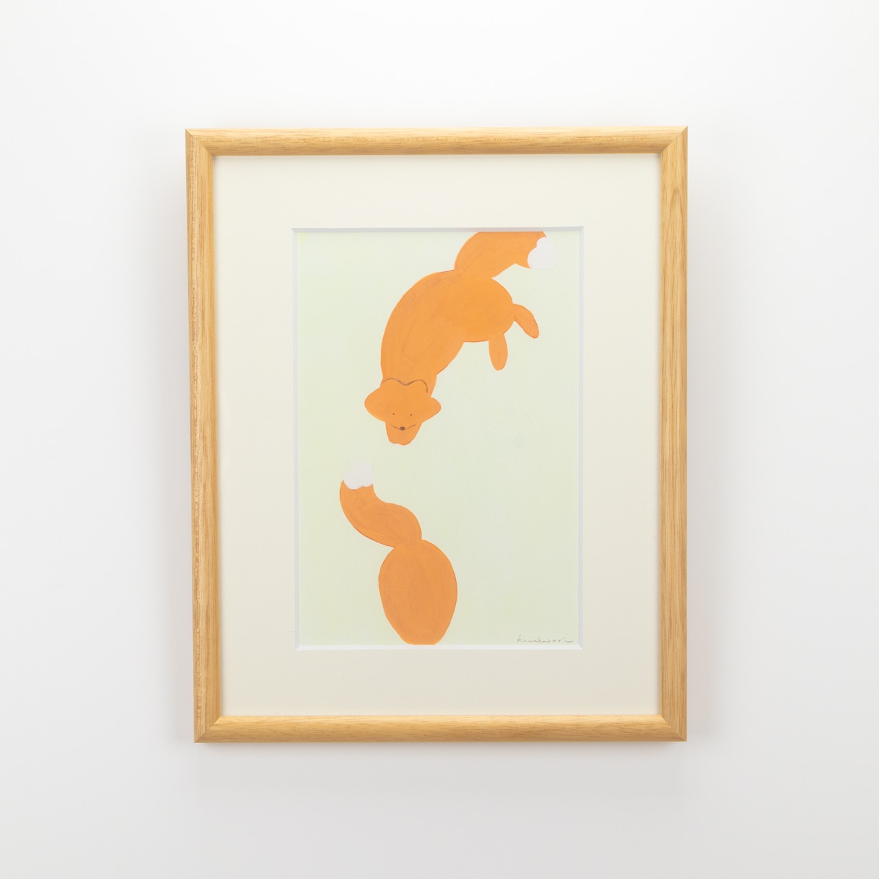 Framed art print showing two orange fox illustrations on a pale green background with a white mat and light wood frame.
