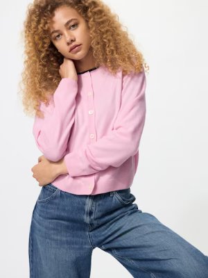 Model wearing a pink cashmere crew-neck cardigan with front buttons.
