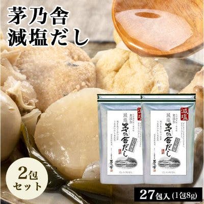 Two white bags of 茅乃舎 減塩だし powdered dashi shown against a soup background.
