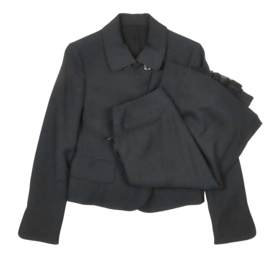 Black wool women's double-breasted jacket with matching midi skirt laid flat on a white background.