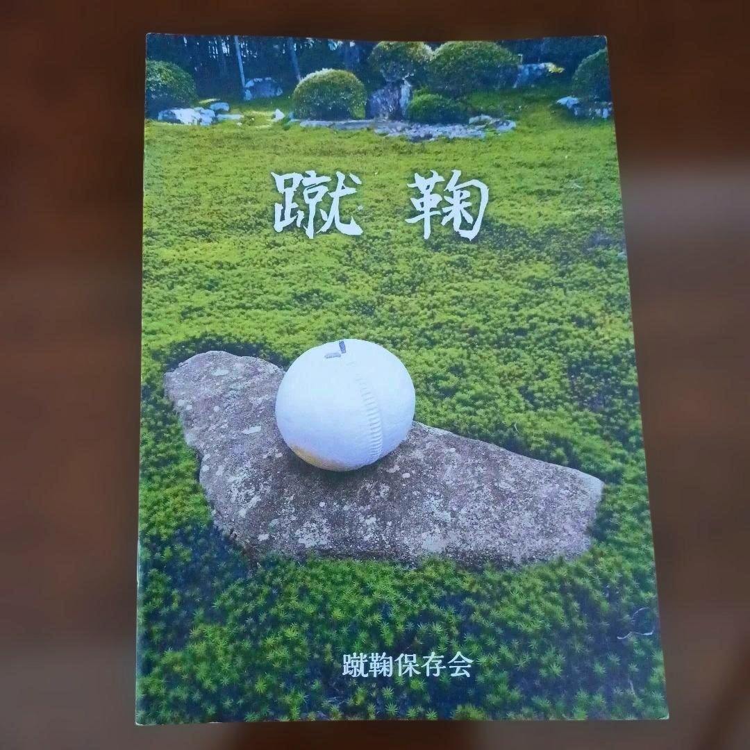 Front cover of 蹴鞠 showing a white ball resting on a rock set against a green mossy background.