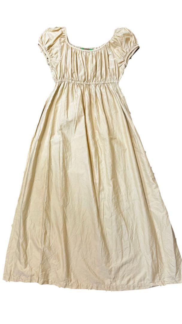 Full-length cream silk gathered dress laid flat showing short sleeves and an elasticated waist.