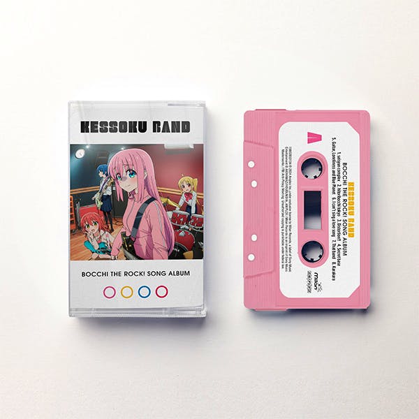 A pink cassette tape next to its clear plastic case showing the KESSOKU BAND Bocchi the Rock! song album cover art.