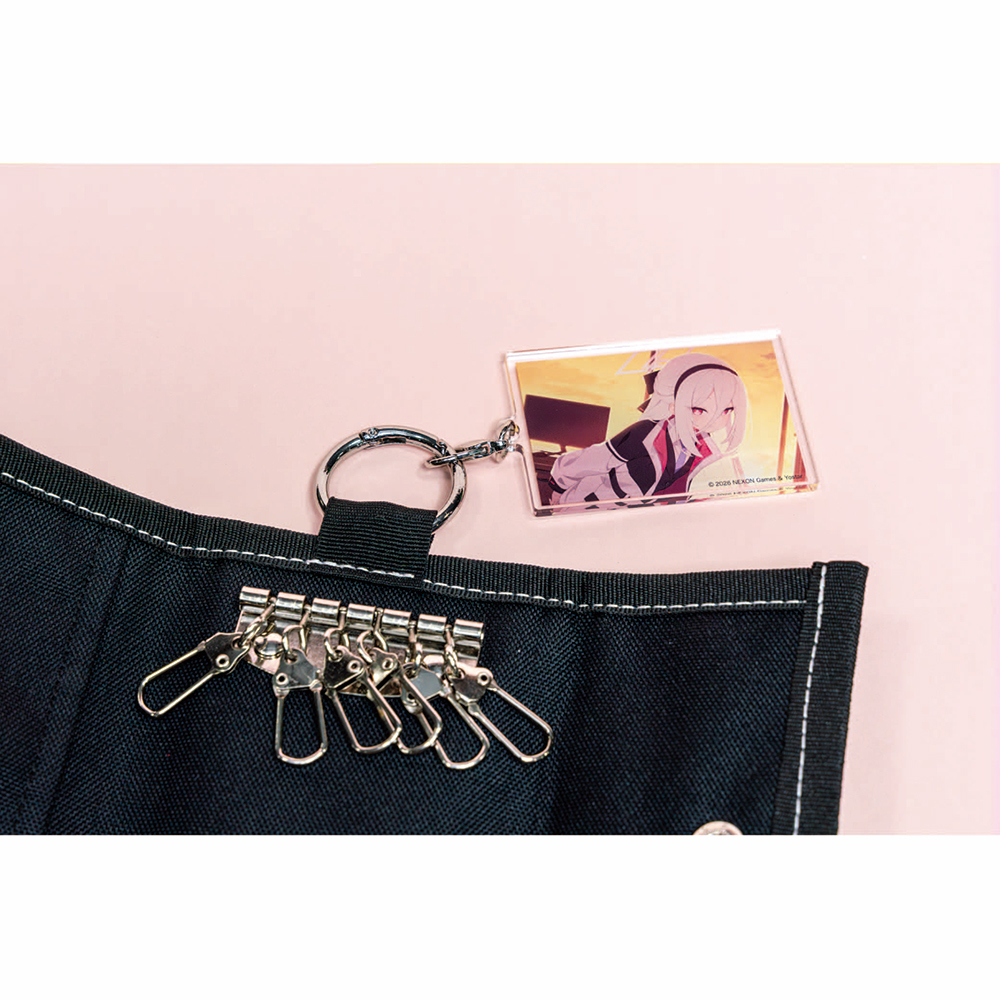 Open black polyester key case showing metal key hooks and a key ring with an acrylic character keychain on a pink background.