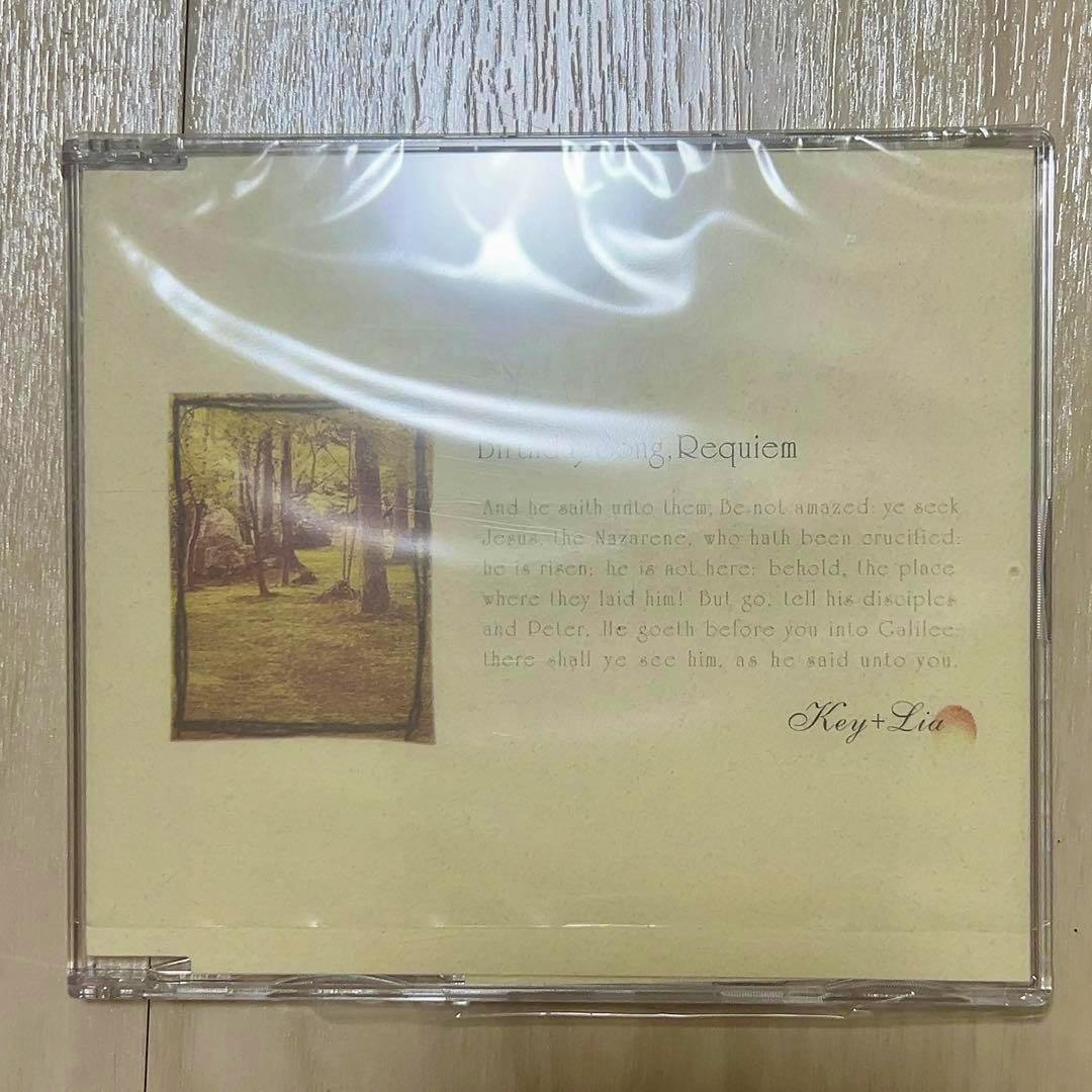 Front cover of the Key+Lia "Birthday Song, Requiem" CD in a clear jewel case, showing pale artwork with a small photo of trees and the Key+Lia name.