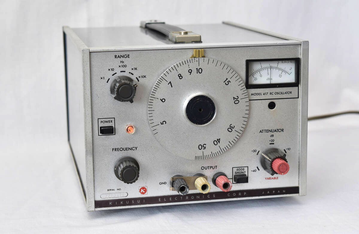 Front view of the KIKUSUI Model 417 RC Oscillator showing the large central tuning dial, meter, control knobs, power indicator, and output terminals.