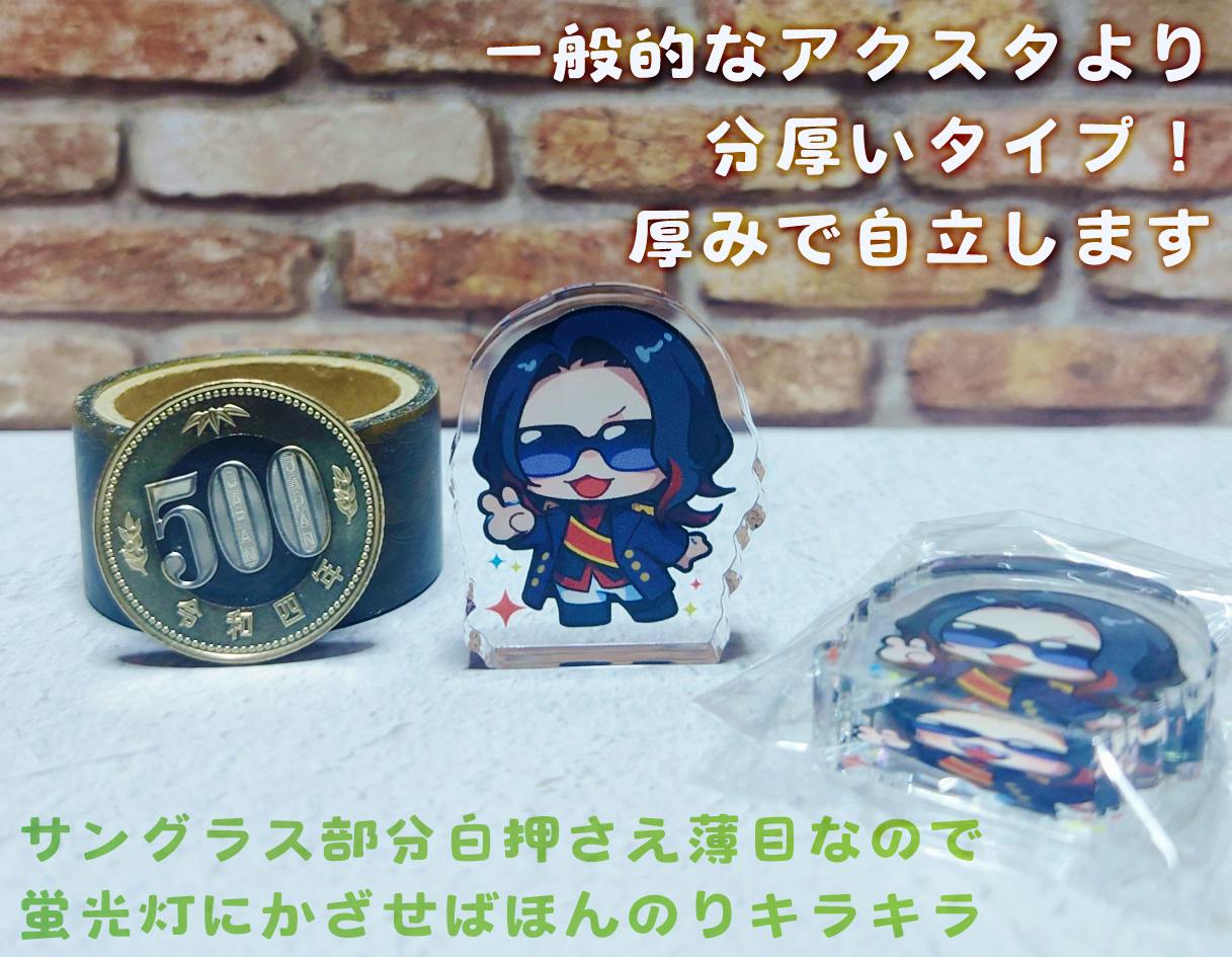 Photograph of the acrylic decorative stand showing the chibi king character standing upright next to a coin and a packaged spare.