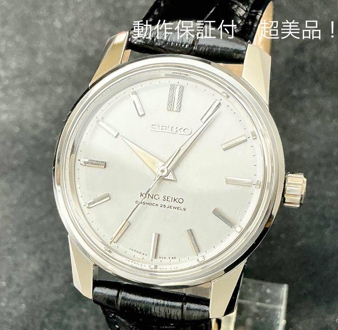 Close-up photo of a King Seiko wristwatch with a silver dial and black leather strap on a display stand.