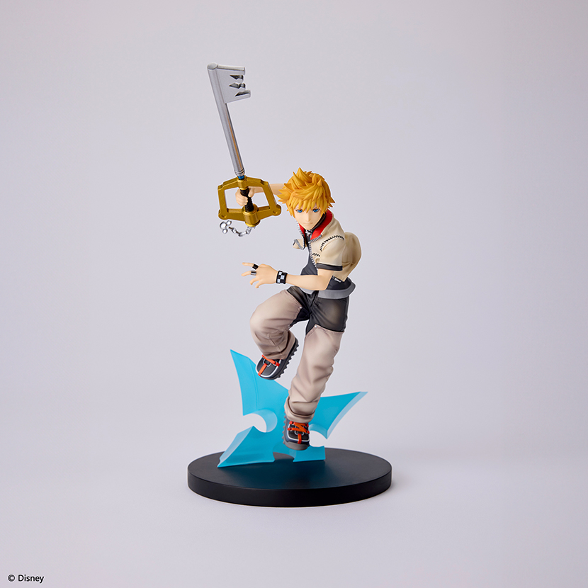 A plastic figure of Roxas from Kingdom Hearts II posed mid-jump on a round base with his Keyblade displayed above him.