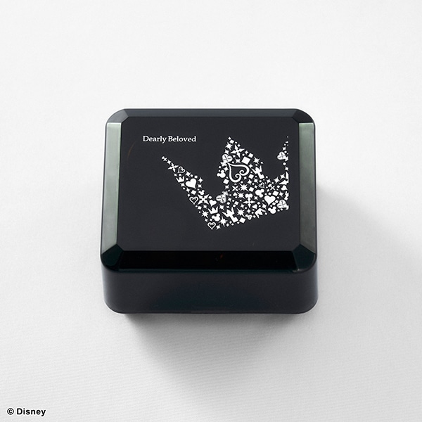 A black music box with a white crown-shaped pattern and the text "Dearly Beloved" on the lid.