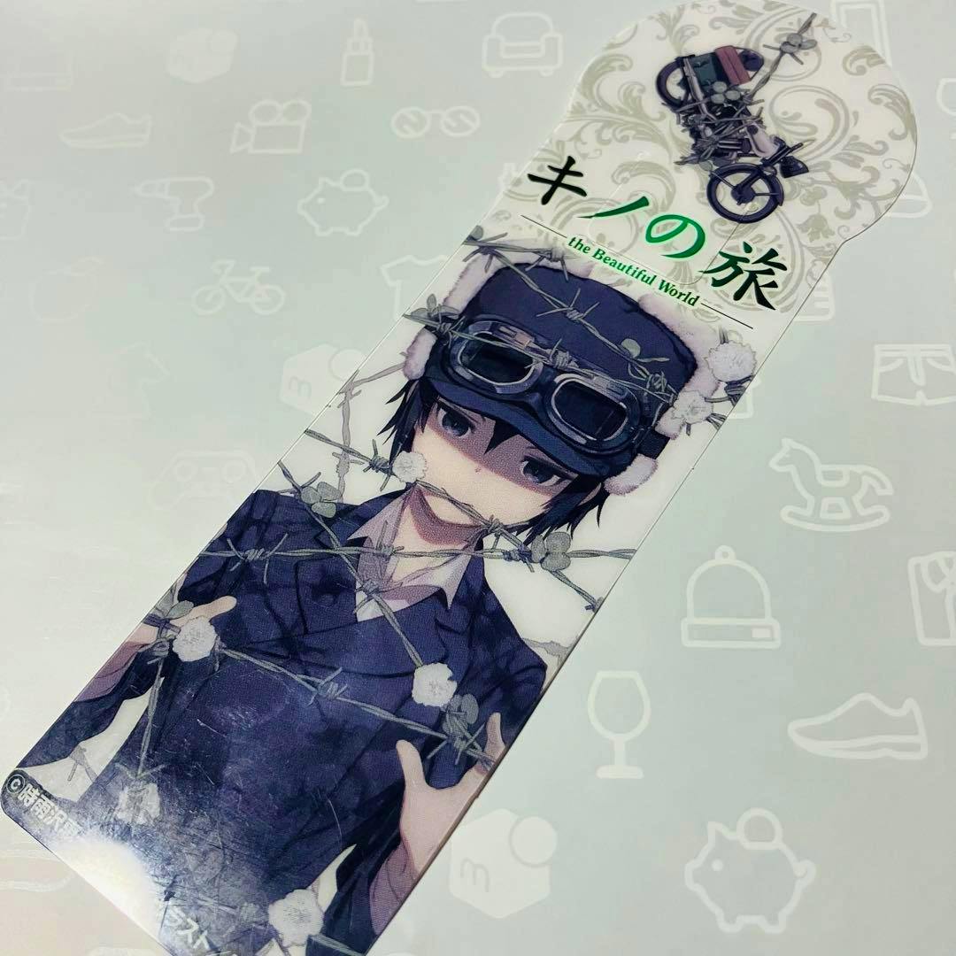 A plastic clear bookmark depicting Kino from "Kino's Journey" wearing goggles with barbed wire artwork and the series title.
